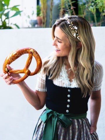 woman holding an Oktoberfest pretzel wearing a dirndl