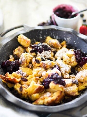 kaiserschmarrn served in a cast iron pan with berry compote