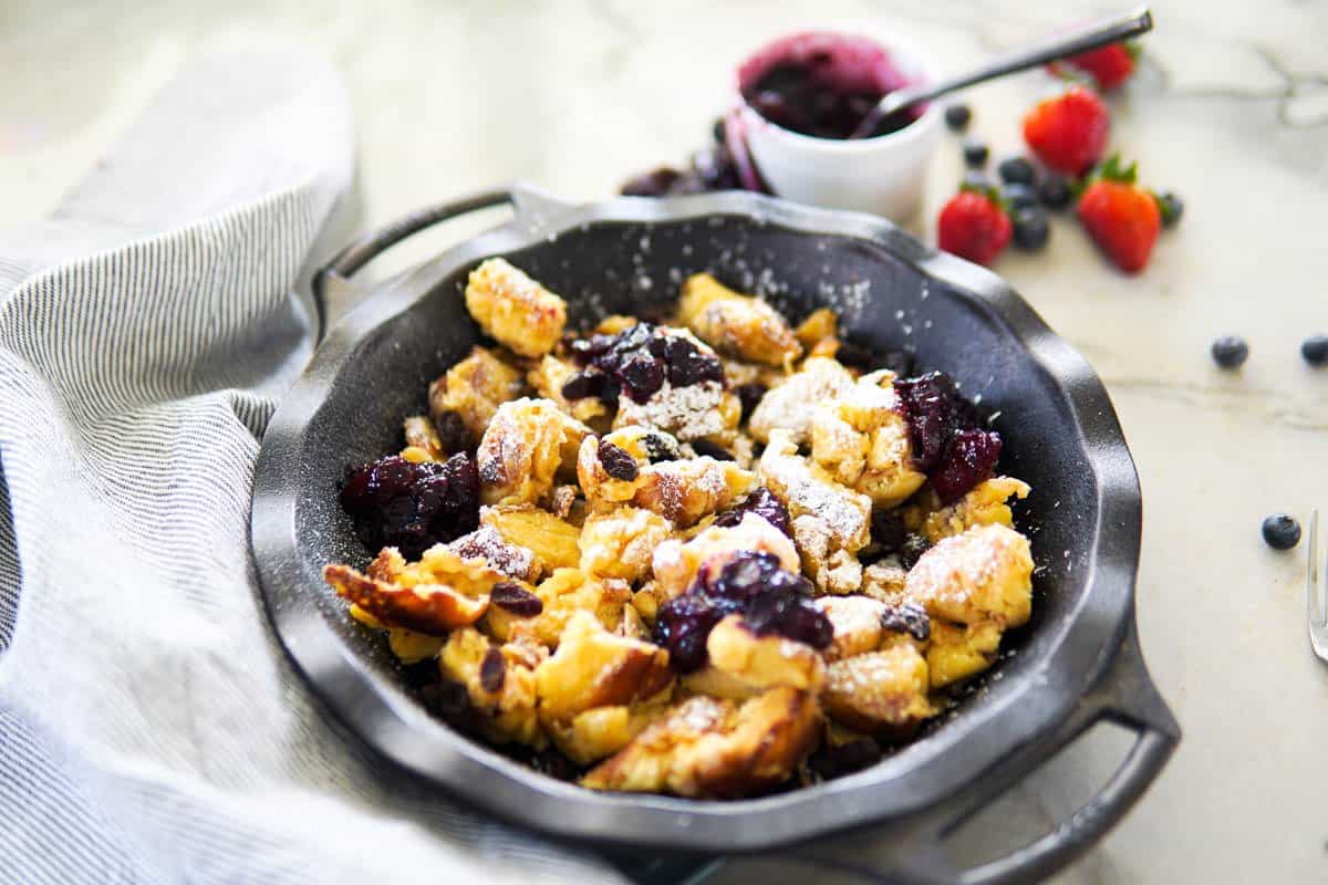 kaiserschmarrn served in a cast iron pan with berry compote