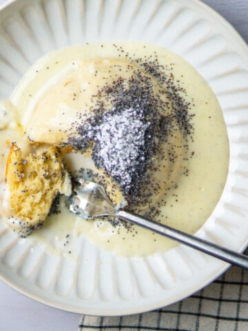 dampfnudel on a plate with vanilla sauce and poppy seed topping