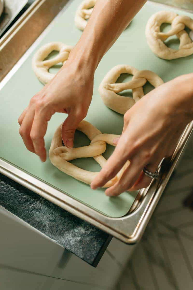 laying pretzels on a baking sheet ready to be baked