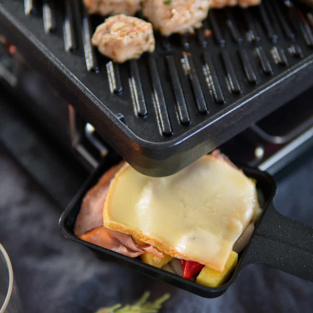 raclette cheese melting on a raclette grill