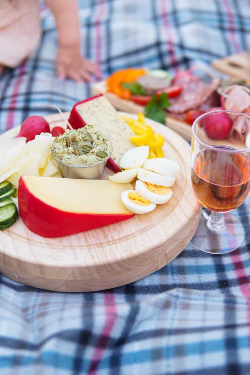 cheese board with pumpkin seed spread on picnic blanket