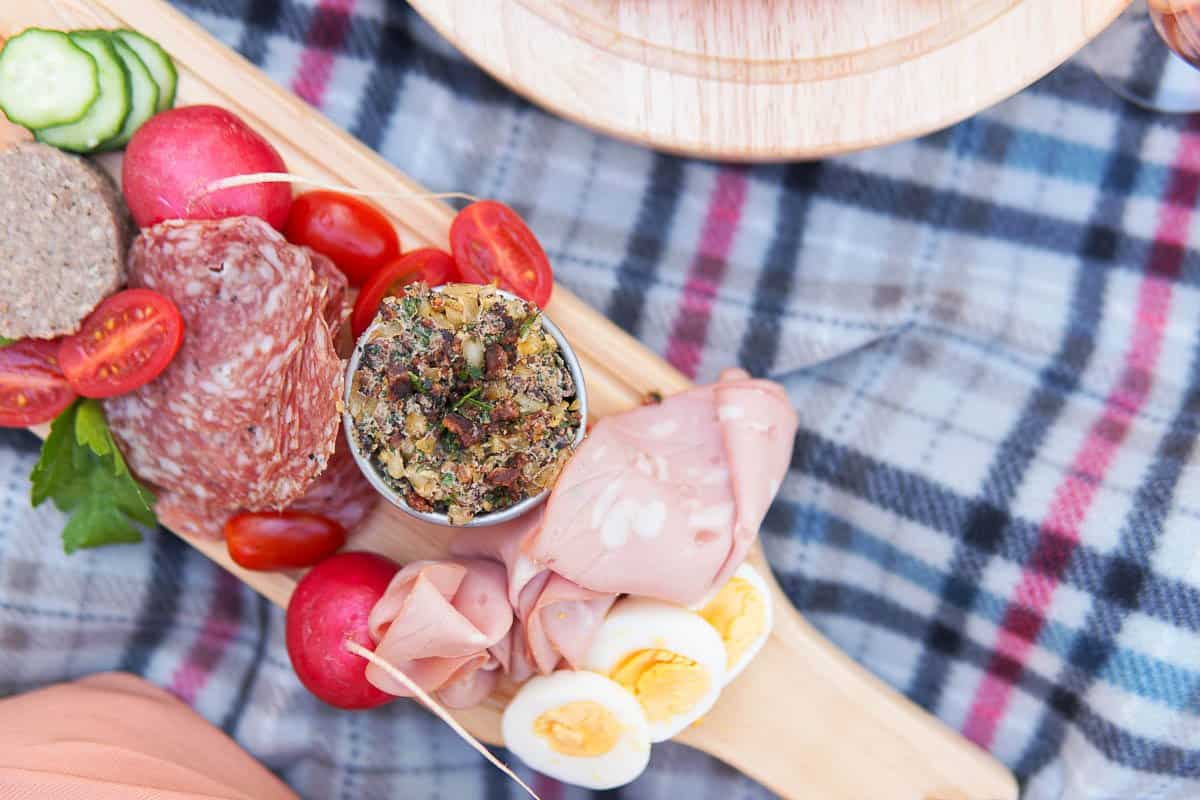 Meat board with bacon spread on a picnic blanket