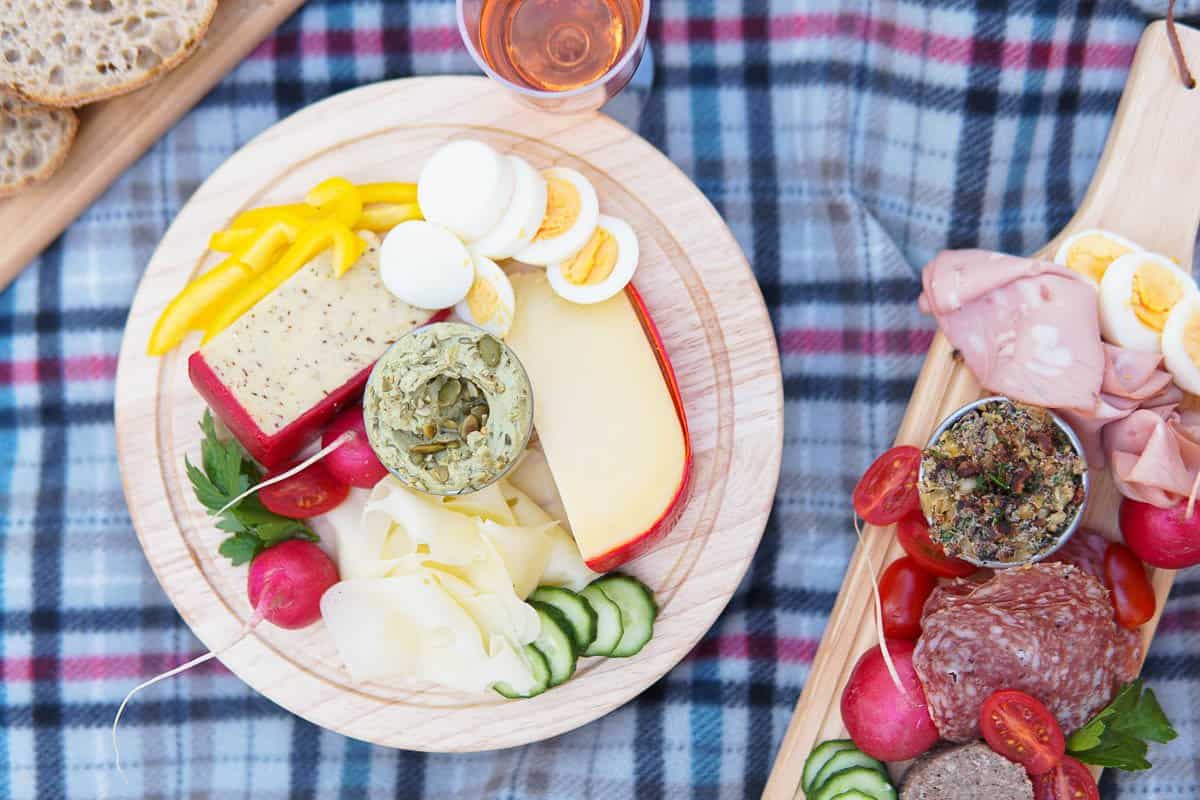 meats and cheese boards on picnic blanket