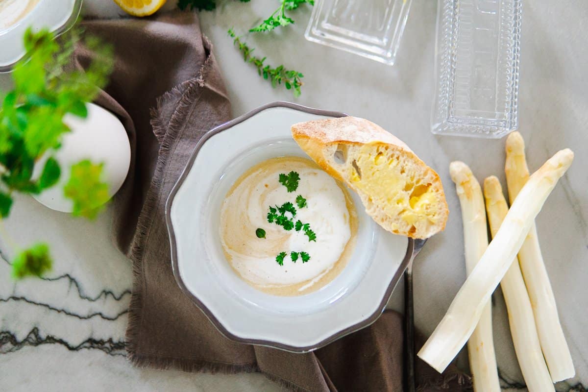 Bowl of white asparagus soup with bread