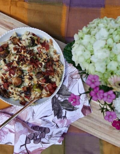 Baked Fall Spätzle arranged with flowers on a wooden board
