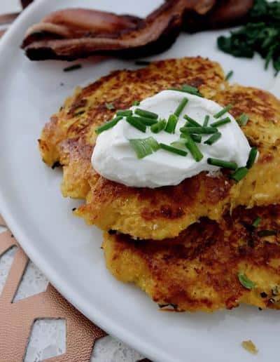 German sweet potato pancakes or Kartoffelopuffer served brunch style with spinach, bacon and egg