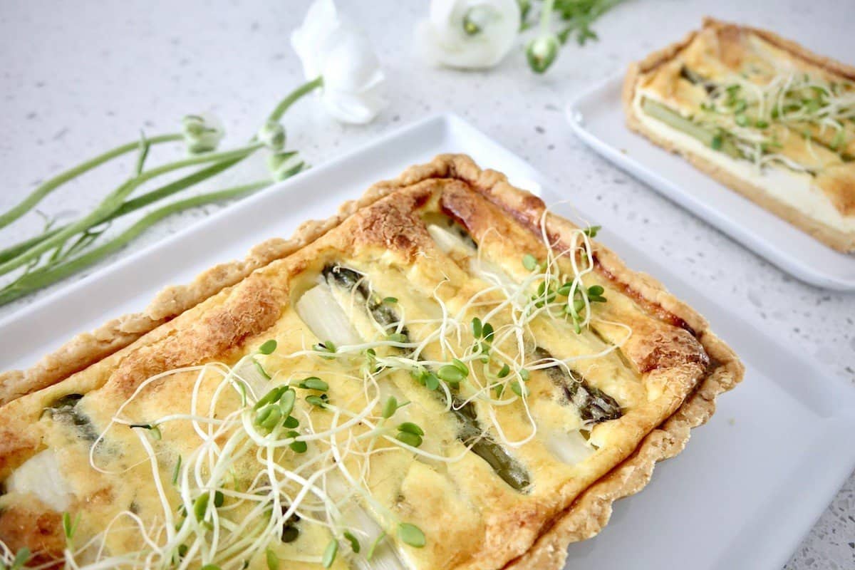 German asparagus quiche on a white plate with flowers