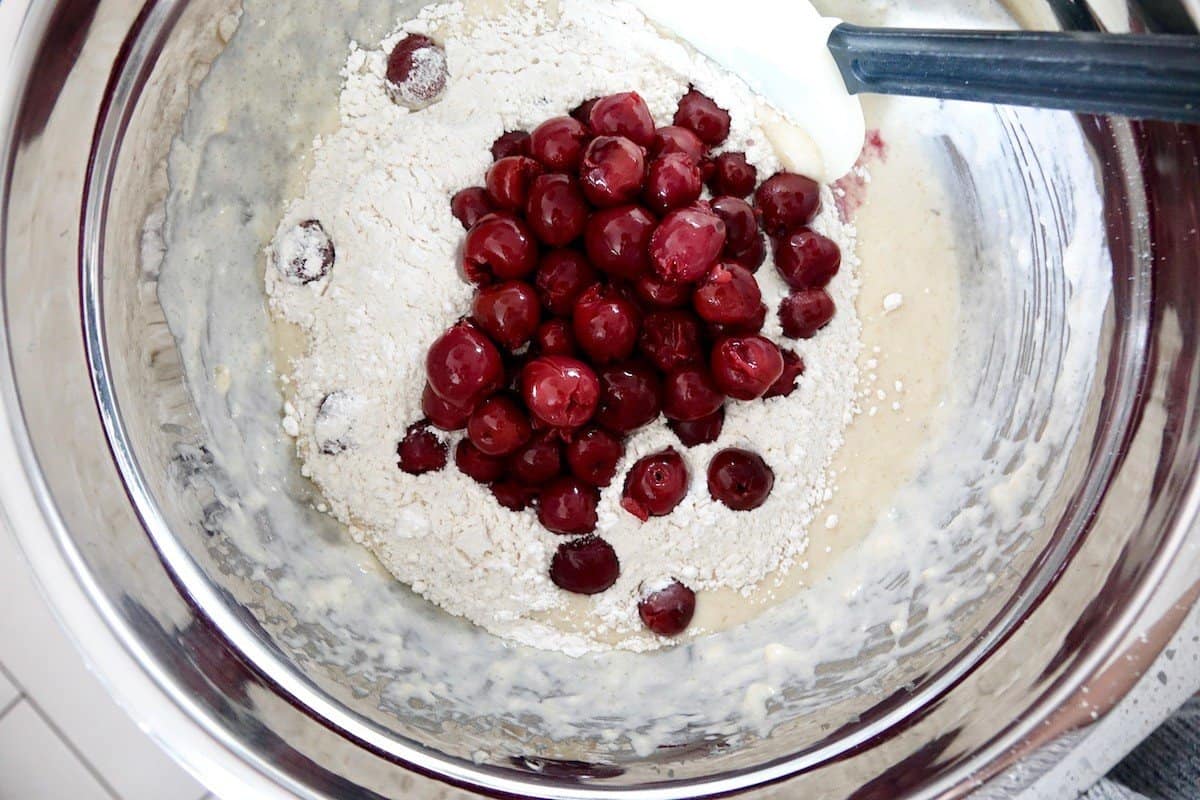 Dropping the cherries on top of the flour to coat them
