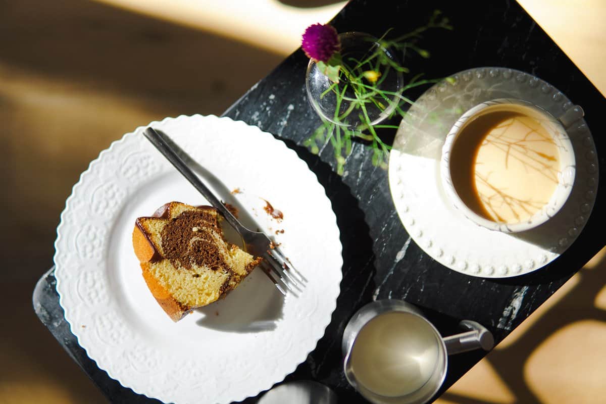 slice of marble cake on a plate and cup of coffee