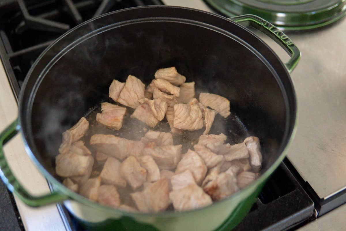 Cooking the pork in a dutch oven pot.
