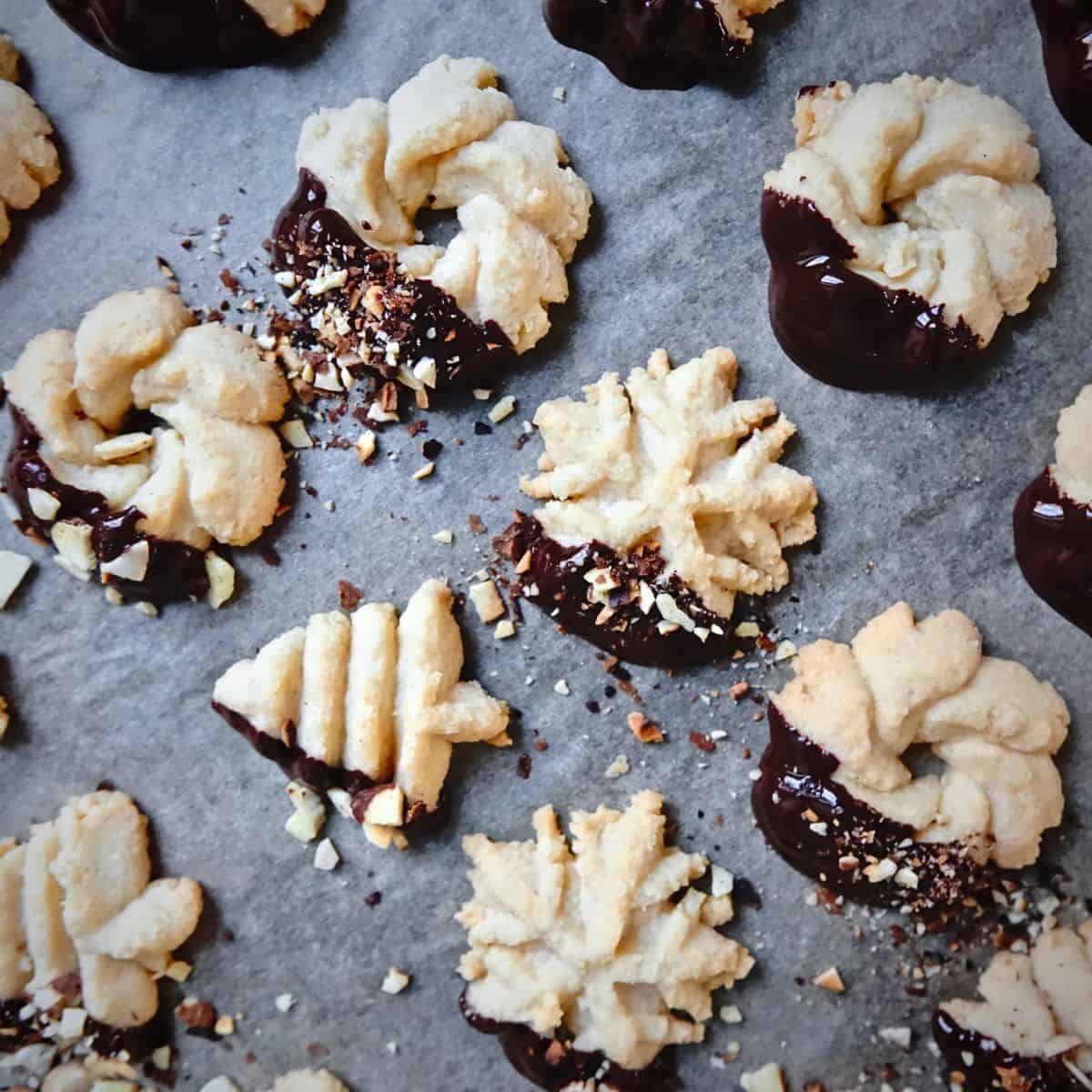 parchment paper topped with chocolate dipped German spritz cookies