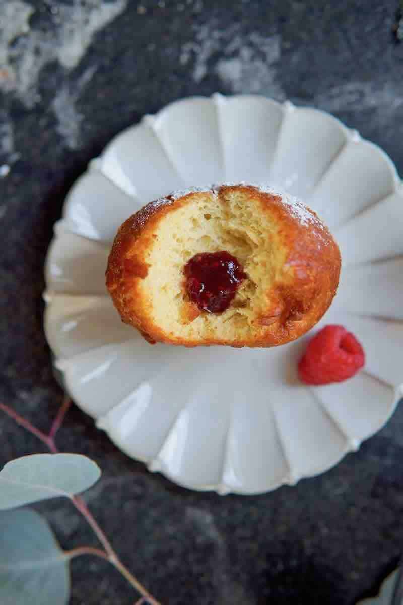 top view of the inside of Berliner donut sitting on a plate