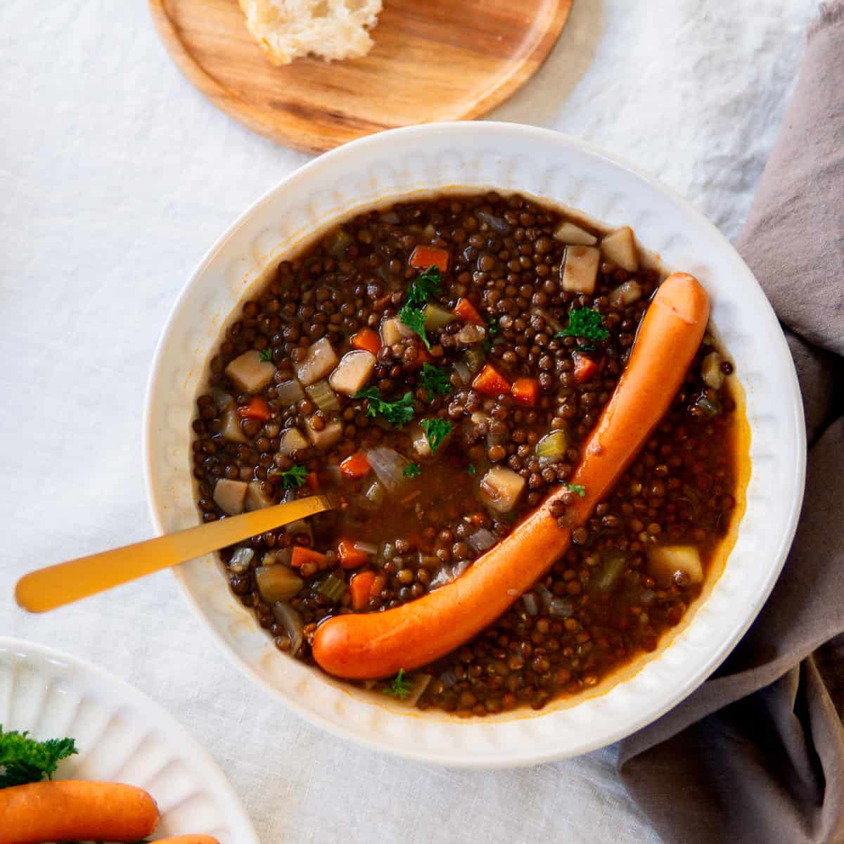 German lentil soup in a bowl with a hot dog
