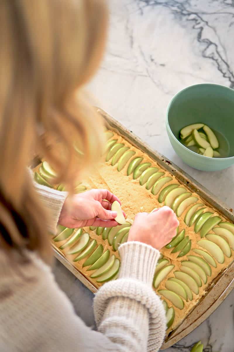 arranging apple slices on cake batter