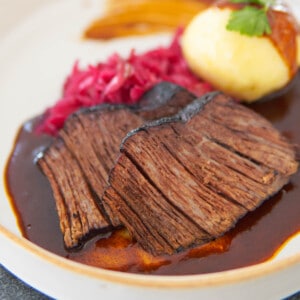 2 slices of Böfflamott German beef roast arranged on a plate with sides