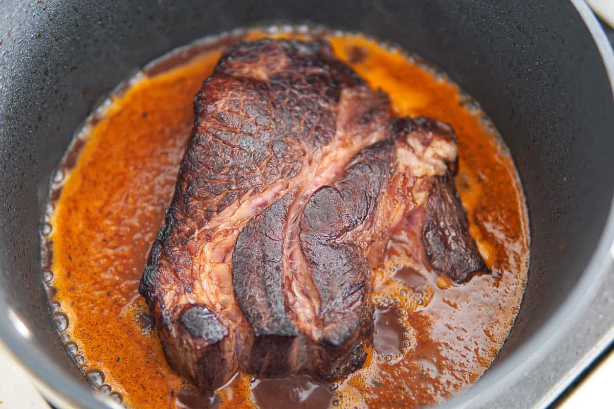 Simmering the beef in the braising liquids