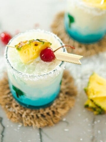 two glasses of swimming pool cocktails and a pineapple