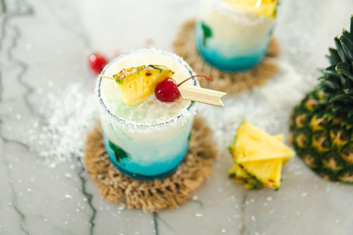 two glasses of swimming pool cocktails and a pineapple