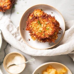 potato pancakes on a white plate with applesauce