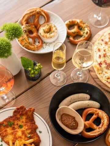 plates of German food surrounded by glasses of wine