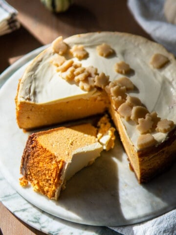 whole pumpkin cheesecake with one slice laying on its side