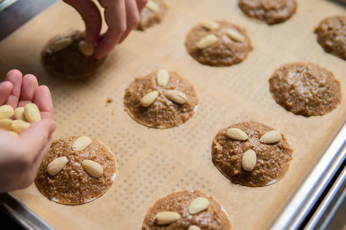 placing blanched almonds on gingerbread cookies