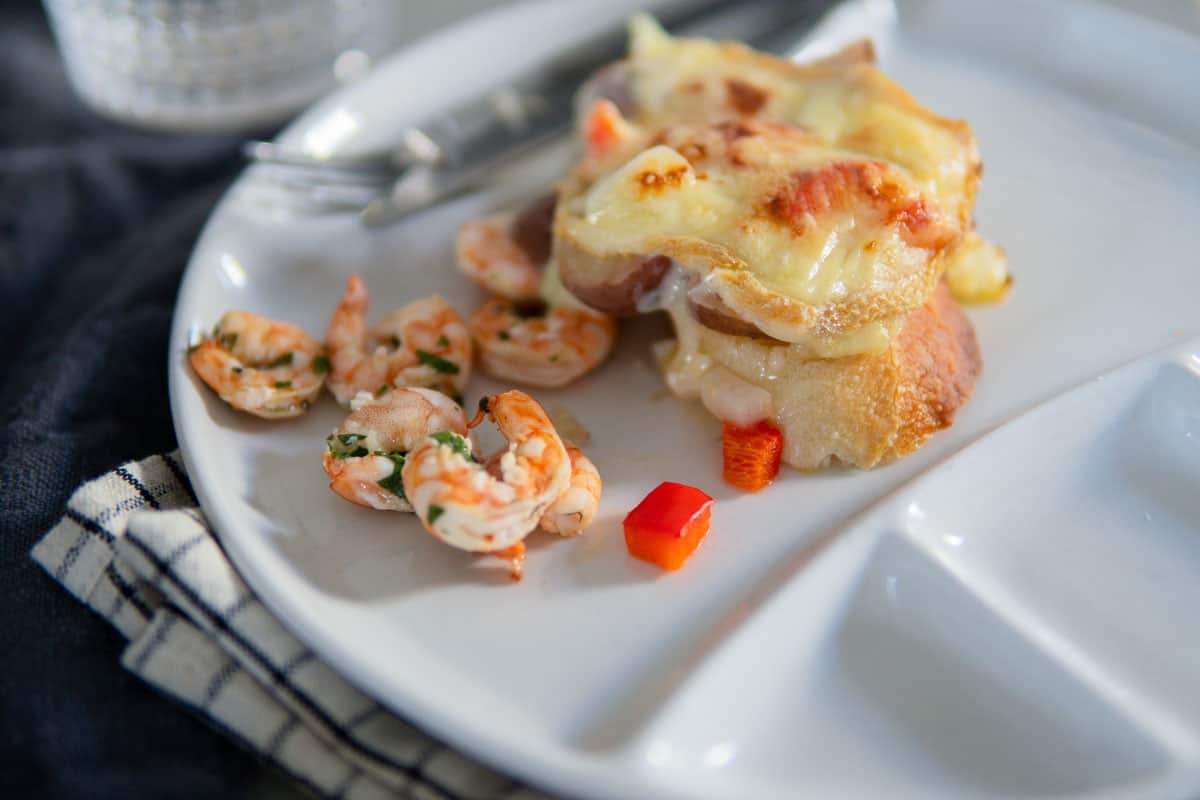 picture of melted raclette cheese on bread and grilled shrimp