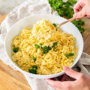 German spätzle noodles in a white serving bowl topped with parsley