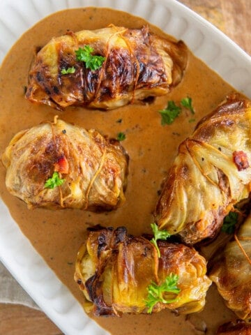 beef stuffed cabbage rolls on an oval platter garnished with parsley