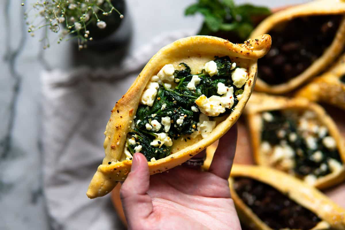 small individual pide filled with sautéed spinach, herbs and feta cheese
