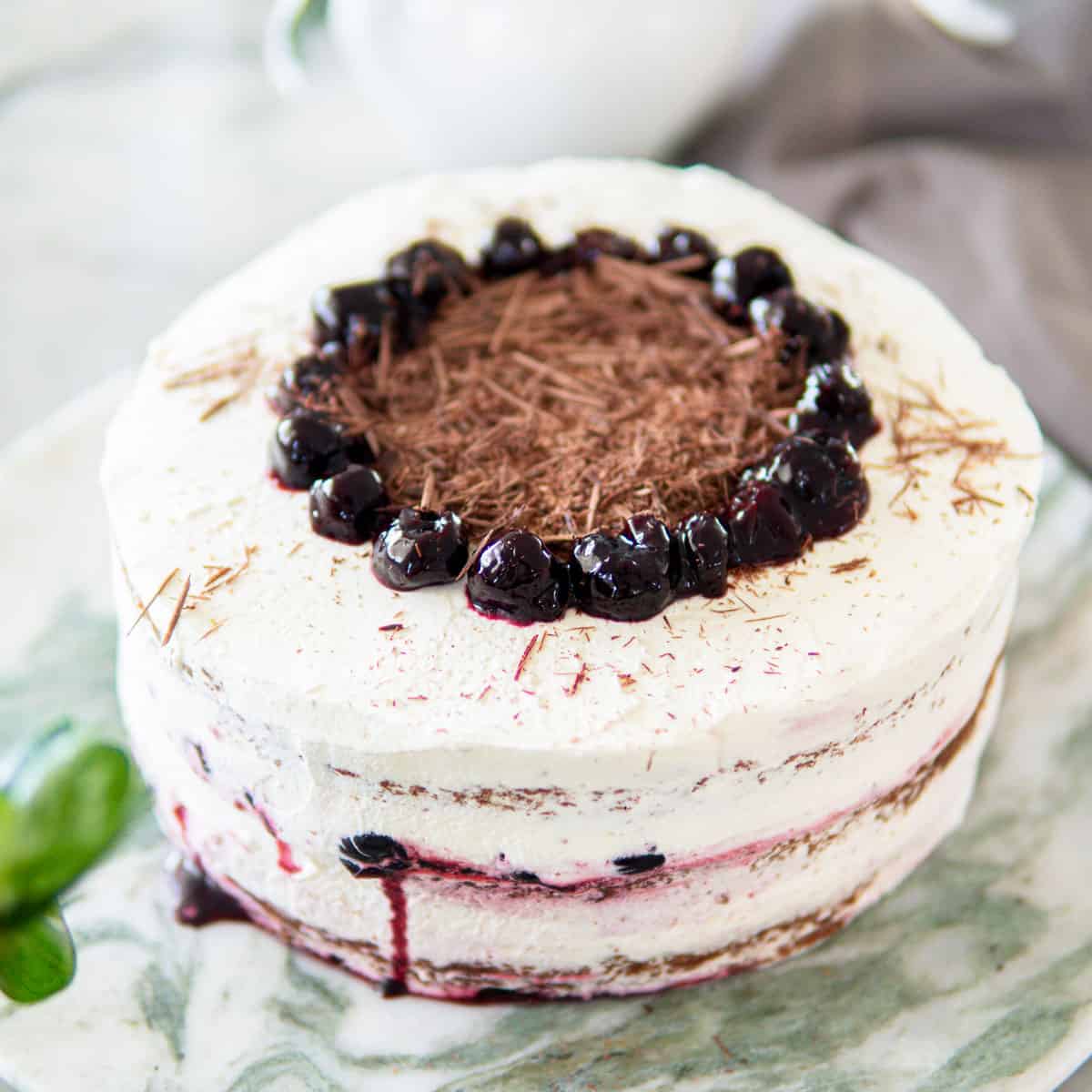 decorated Black Forest cake sitting on a green marble platter