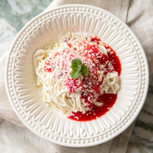 white bowl with spaghetti ice cream topped with a mint leaf