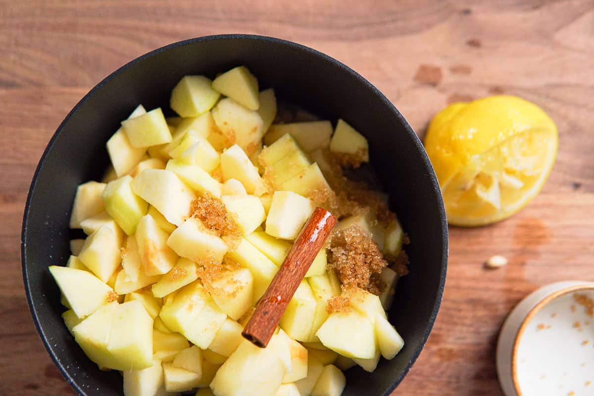 a pot filled with apple chunks, spied and sugar.