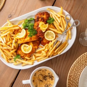 German pork schnitzel on a platter with fries and lemon