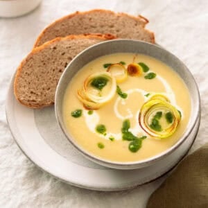 German leek and potato soup in a soup bowl with slices of German rye bread