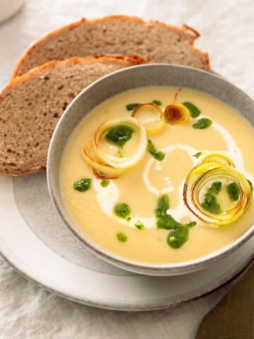 German leek and potato soup in a soup bowl with slices of German rye bread