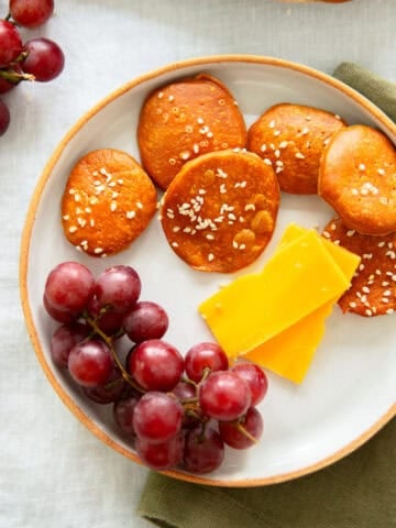 pretzel crackers on a plate with grapes and cheese