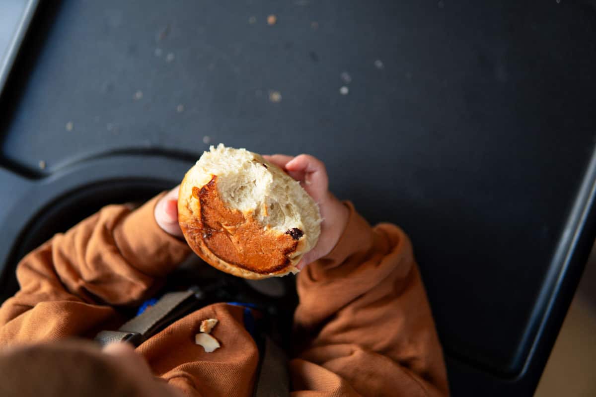 A child holding a half-eaten roll from the Dreikönigskuchen.