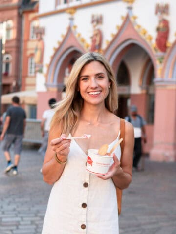 Sophie Sadler holding spaghetti ice cream and standing in a German pedestrian zone.