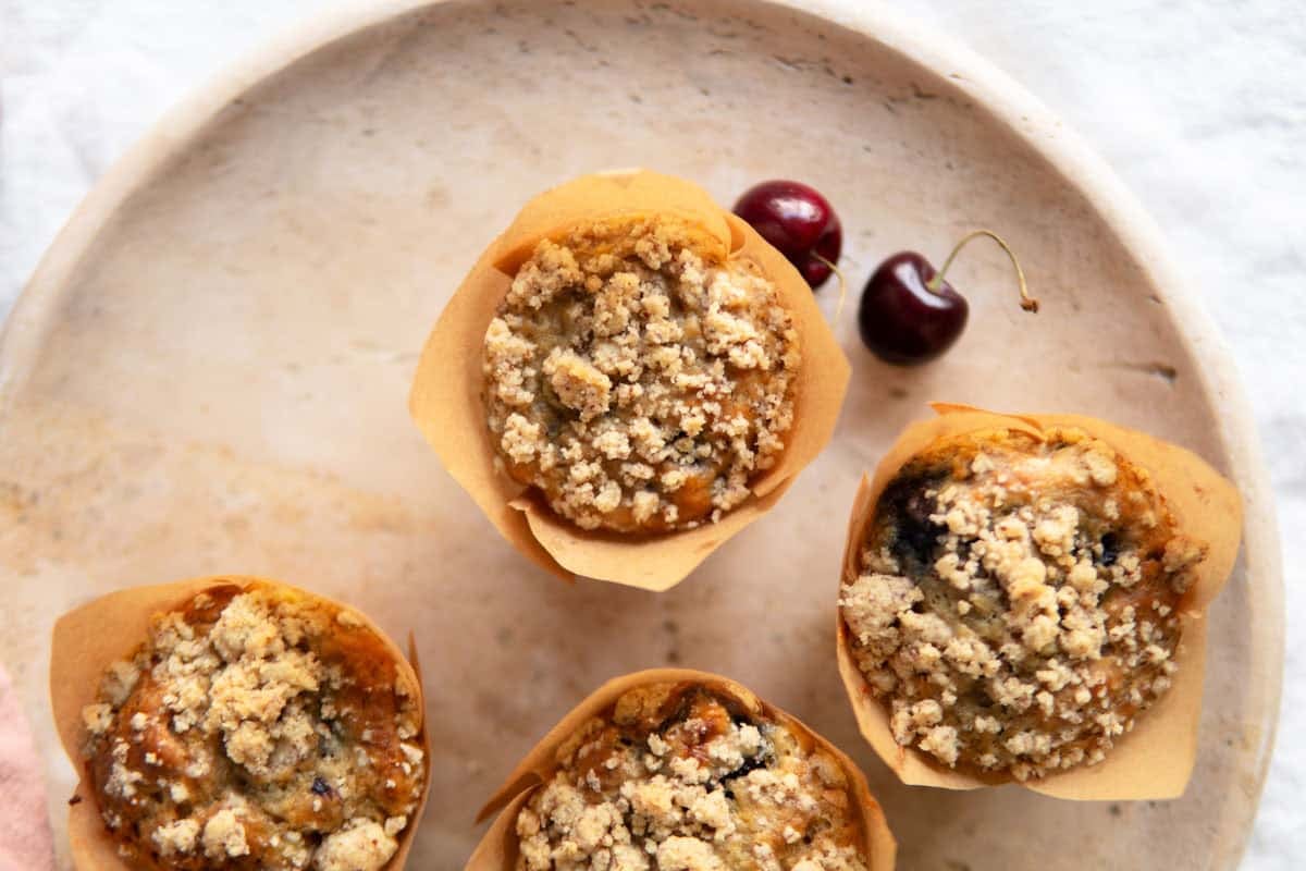 Top view of baked banana cherry muffins on a platter.