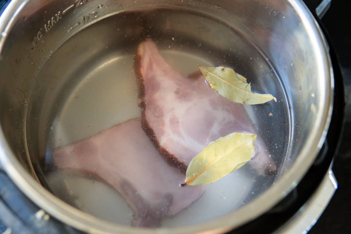 Kassler meat, bay leaves and water in Instant Pot before cooking.