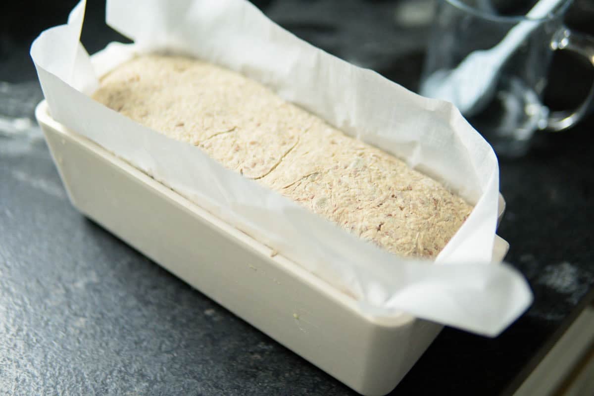 Unbaked bread in a ceramic loaf pan.
