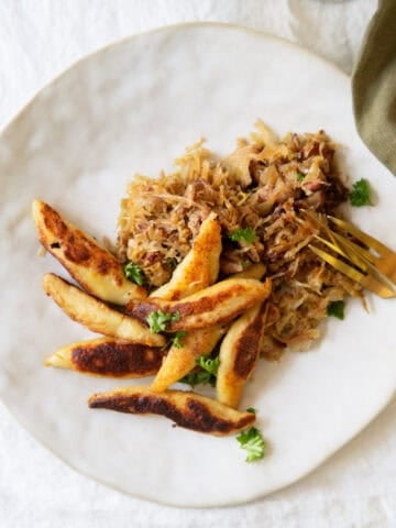 Plated German potato noodles with sauerkraut underneath and parsley on top