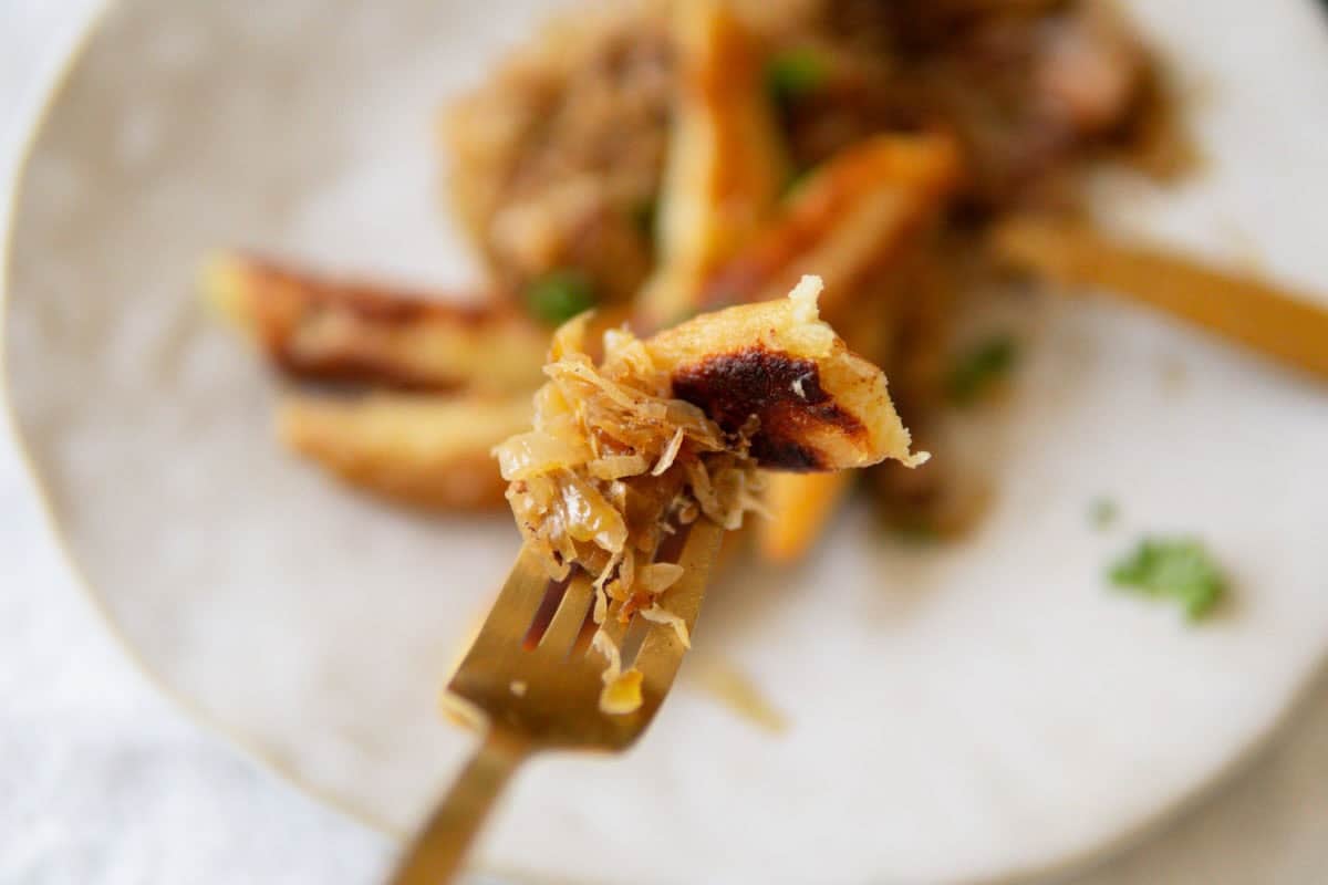 A bite of Schupfnudeln with sauerkraut on a fork.